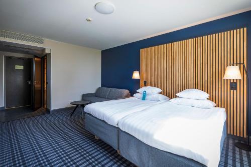 a hotel room with a large bed and a chair at Break Sokos Hotel Koli in Kolinkylä