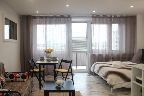Schlafzimmer mit einem Bett, einem Tisch und Stühlen in der Unterkunft Sunny City Center Apartment in Warschau