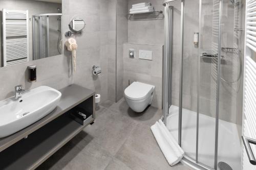 a bathroom with a toilet and a sink and a shower at Ala hotel in Bystřice nad Pernštejnem