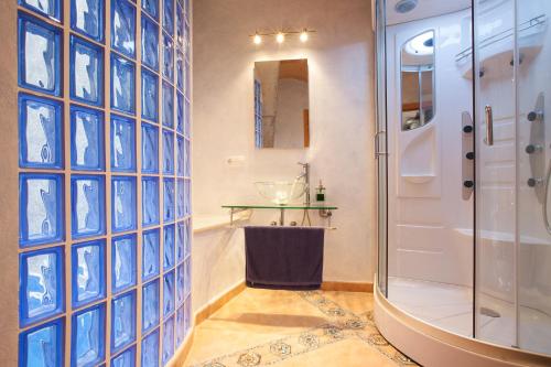 baño con ducha y pared de cristal en Casa Aina, 15, en Pollensa