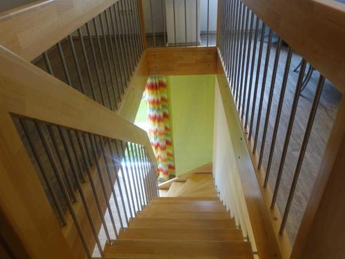 a staircase in a house with wooden rails at Ferienwohnung Regenbogenhaus in Hasselberg