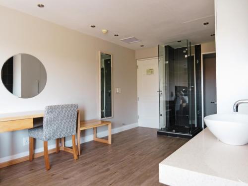 a bathroom with a sink and a desk and a tub at San Lameer Resort Hotel & Spa in Southbroom