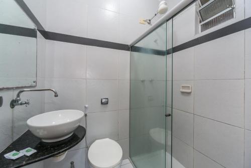 a bathroom with a toilet and a glass shower at Hotel Pousada da Praia in Recife