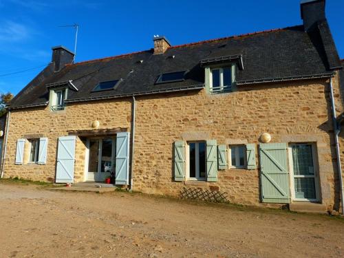 un ancien bâtiment en briques avec des portes et des fenêtres vertes dans l'établissement La Ferme Du Vincin, à Vannes