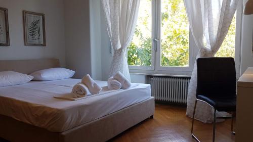 1 dormitorio con 1 cama, 1 silla y 1 ventana en Violet Errathens Apartment - Athens Center, 7 BD, 3 BATH en Atenas
