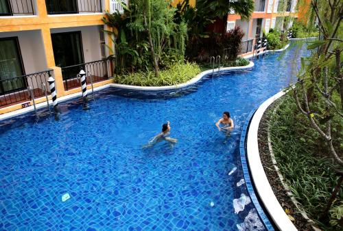 two people in a swimming pool at a hotel at Venetian Poseidon Pool Hotel in Jomtien Beach