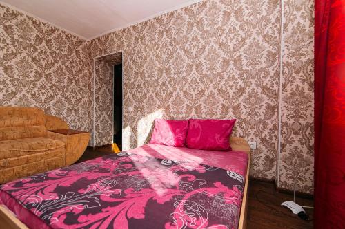 een slaapkamer met een roze bed en een bank bij Apartmens Faraon On Illinskaya 5 floor New Building in Sumy