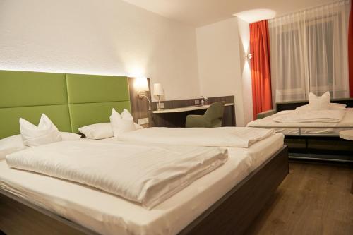 a hotel room with two beds and a desk at Insel-Hotel-Lindau in Lindau