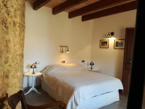 a bedroom with a white bed and two tables at Pina in Pina