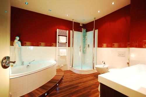 a bathroom with a tub and a shower and a toilet at Hotel Binz in Bernkastel-Kues