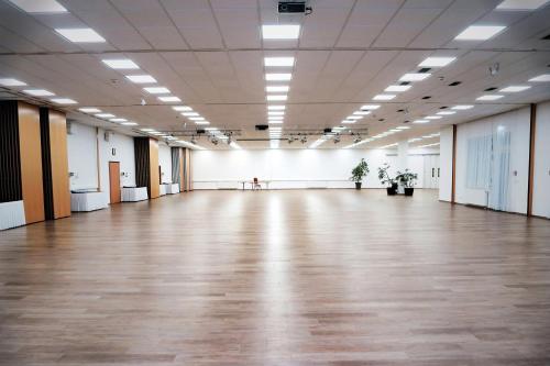 an empty room with a large hall with wooden floors at NOVAPARK Flugzeughotel Graz in Graz