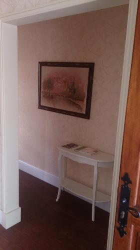 a table in a room with a painting on the wall at Le Pontet in Miramont-de-Guyenne