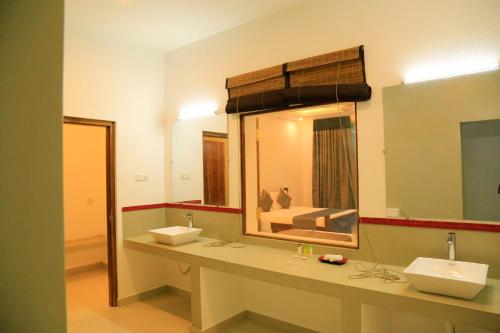 a bathroom with two sinks and a large mirror at Tara Watergate in Tissamaharama