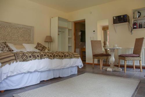 a bedroom with a bed and a table and chairs at ALEHUE Casa de Montaña in Villa La Angostura
