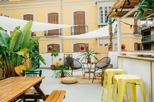 a room with a table, chairs, and a balcony at The Urban Jungle Hostel in Málaga