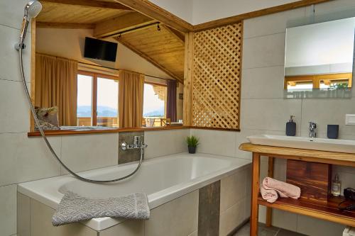 ein Badezimmer mit einer Badewanne und einem Waschbecken in der Unterkunft Dopplerstubn in Agsdorf