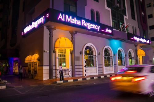 a building with aania registry on a street at night at Al Maha Regency Hotel Suites - Managed by Aoudi Consultants in Sharjah