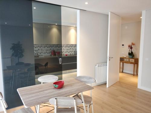 a kitchen and dining room with a wooden table and chairs at Rafaelo's Apartment in Caldas da Rainha