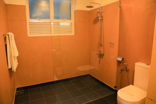 a bathroom with a shower and a toilet at Tara Watergate in Tissamaharama