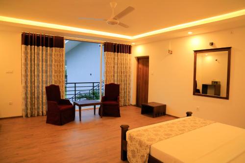a hotel room with a bed and a balcony at Tara Watergate in Tissamaharama