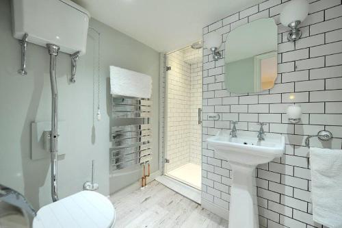 a white bathroom with a toilet and a sink at Little Monmouth 4 bedroom cottage, Old town Lyme Regis, dog friendly and parking in Lyme Regis