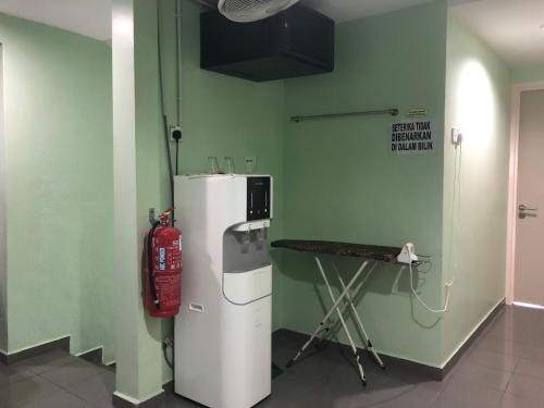 a room with a white refrigerator and a fire extinguisher at Best Seven Motel in Kuah