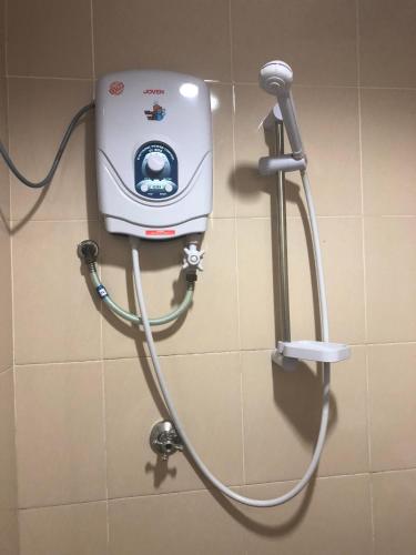 a soap dispenser on a wall in a bathroom at Best Seven Motel in Kuah