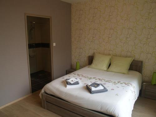 ein Schlafzimmer mit einem Bett mit zwei Handtüchern darauf in der Unterkunft LES JARDINS DE LA GRANGE in Rezonville