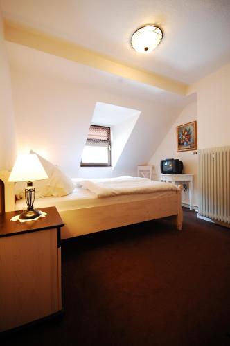 a bedroom with a bed and a lamp on a table at Hotel Binz in Bernkastel-Kues