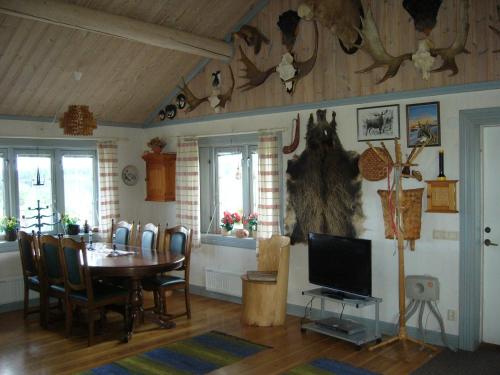 a dining room with a table and a television in it at Panoramaboende in Torsby