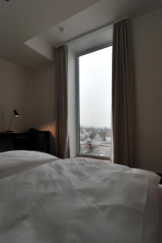 a bedroom with a large window with a view at Guggach Apartôtel in Zürich