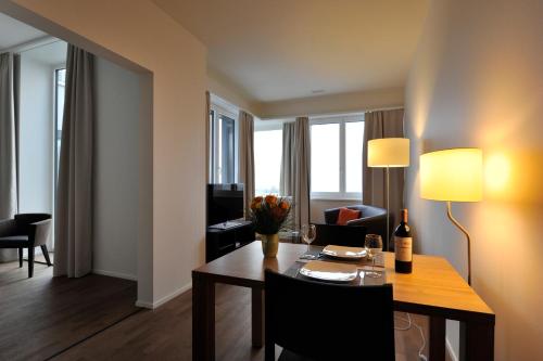 a room with a dining table and a living room at Guggach Apartôtel in Zürich