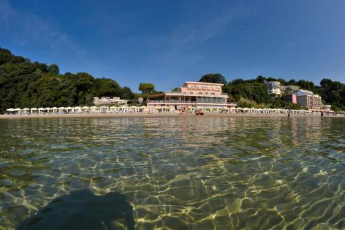 a view of a beach with a building in the water at Grand Hotel Il Ninfeo in Gaeta
