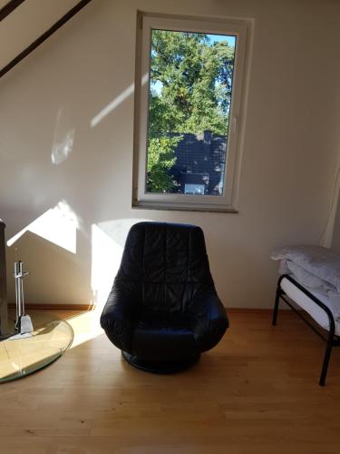 a black chair sitting in a room with a window at villa high ceiling 2 bedrooms in Troisdorf