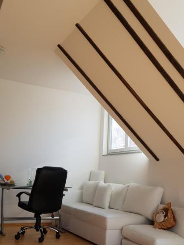 a living room with a white couch and a desk at villa high ceiling 2 bedrooms in Troisdorf