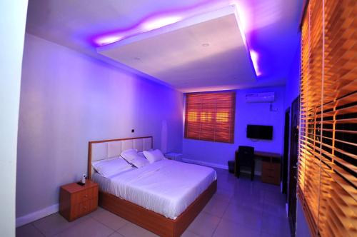 a bedroom with a bed with purple lights on the ceiling at HIS Dulce Apartments in Lagos