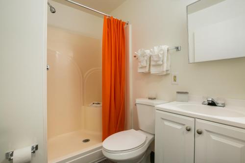 - un rideau de douche orange dans la salle de bains pourvue de toilettes dans l'établissement Siegel Select Albuquerque 2, à Albuquerque