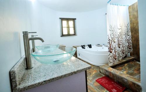 a bathroom with a bowl sink and a tub at HIS Dulce Apartments in Lagos