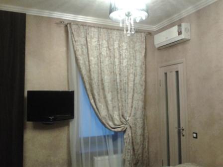 una camera con tenda, televisore e finestra di Annabelle отель a Odessa
