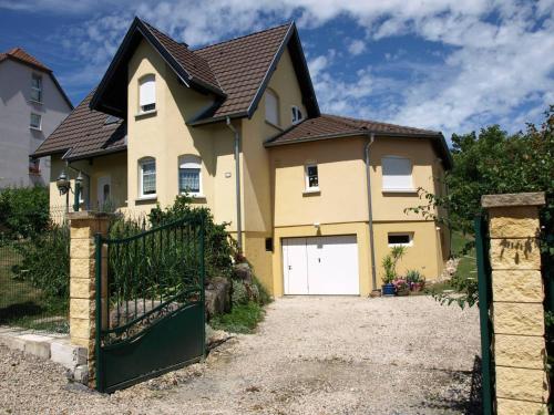 a large yellow house with a white garage door at Chez Olivier et Josette sur Mulhouse Sud in Illfurth