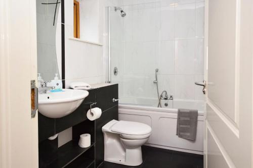 Apartment 709 Letterfrack في ليترفراك: حمام ابيض مع مرحاض ومغسلة