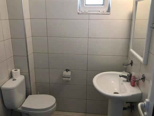 Baño pequeño con aseo y lavamanos en Kedros Rooms en Prasonisi
