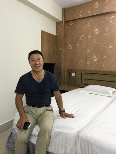 a man sitting on top of a bed at Hotel Seven Star in Dhaka
