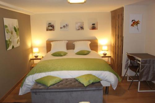 a bedroom with a large bed with green pillows at Chambre d'hotes Antony in Fresnes
