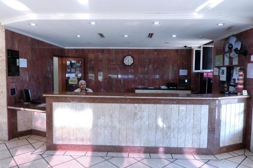 a man standing behind a bar in a restaurant at Hotel Almanara Cuiabá-Mato Grosso-Brasil in Cuiabá