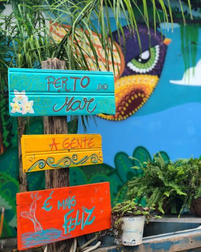 a group of signs on a pole with plants at Pousada Vila Campeche in Florianópolis