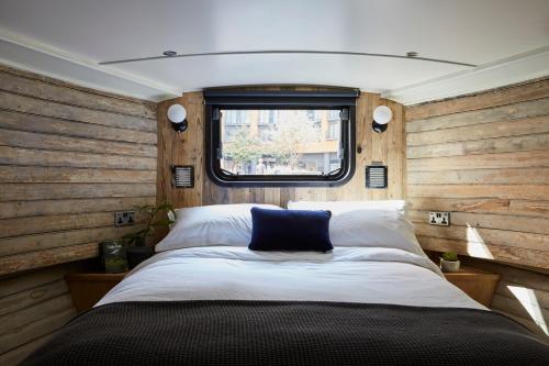 Un dormitorio con una cama grande con ventana. en The Boathouse, en Londres