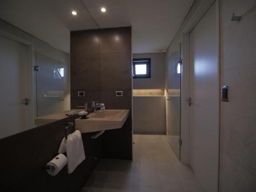 y baño con lavabo, ducha y espejo. en Pizzorno Lodge & Wine, en Progreso