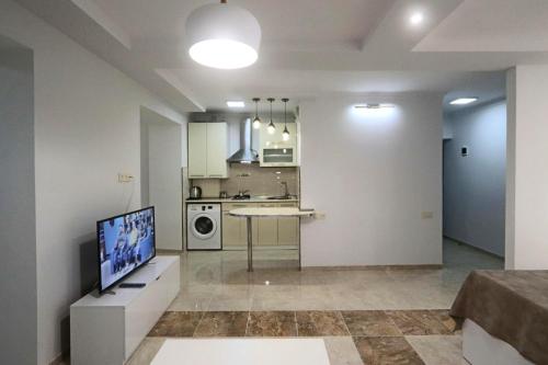 a living room with a television and a kitchen at Appartment Lux, Komitas 26 in Yerevan