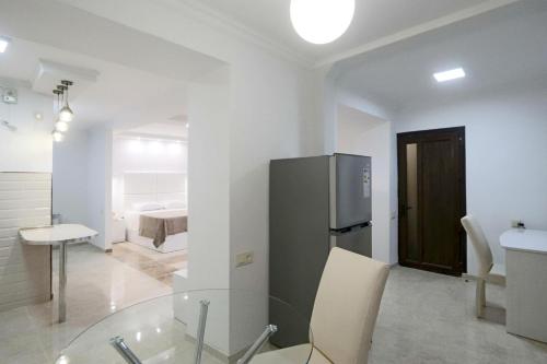 a kitchen with a glass table and a refrigerator at Appartment Lux, Komitas 26 in Yerevan